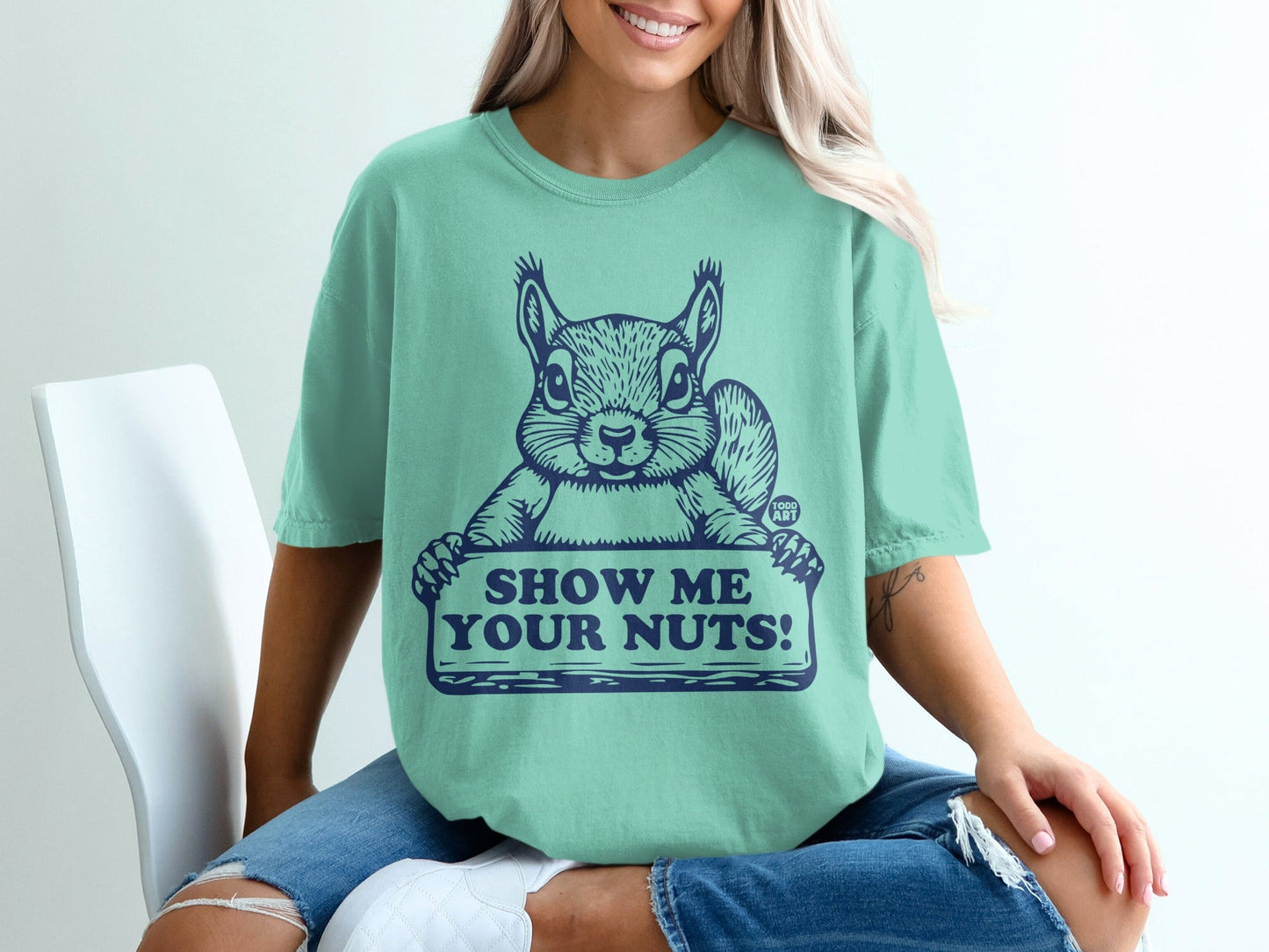 Teal t-shirt with squirrel holding "Show Me Your Nuts!" sign.