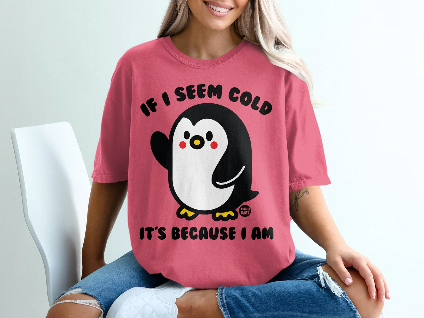 Pink t-shirt with a cartoon penguin and text "IF I SEEM COLD IT'S BECAUSE I AM".