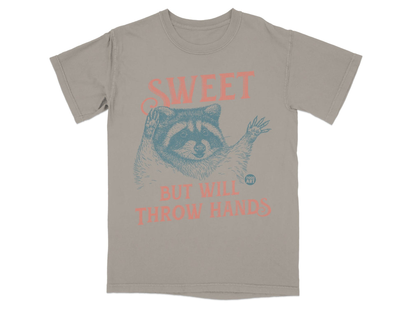 T-shirt with raccoon illustration and text "SWEET BUT WILL THROW HANDS".