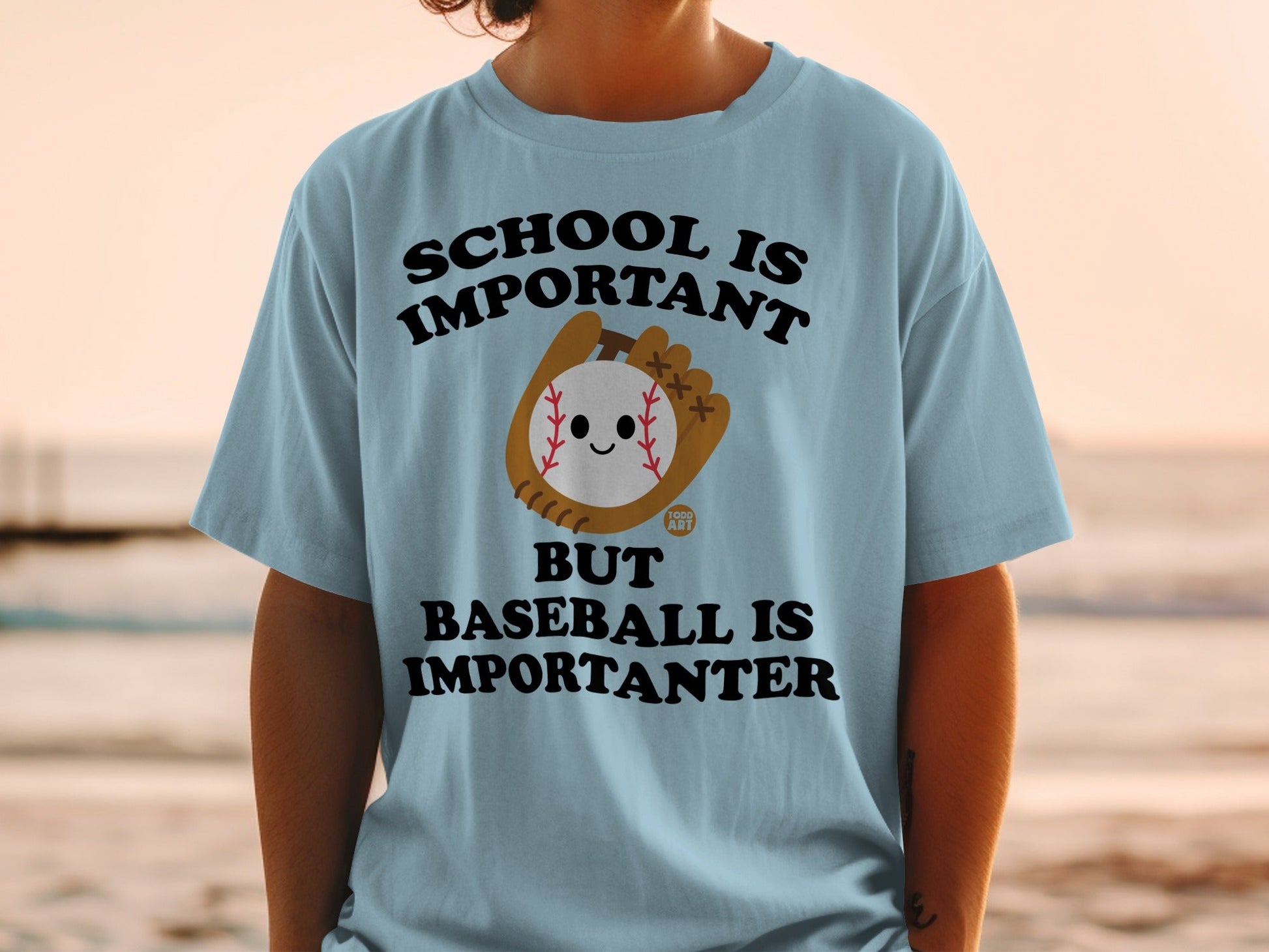Light blue t-shirt with "School is important but baseball is importanter" text and baseball graphic.