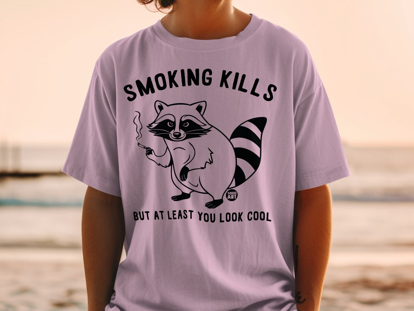 T-shirt with raccoon smoking a cigarette and text "Smoking Kills But At Least You Look Cool."