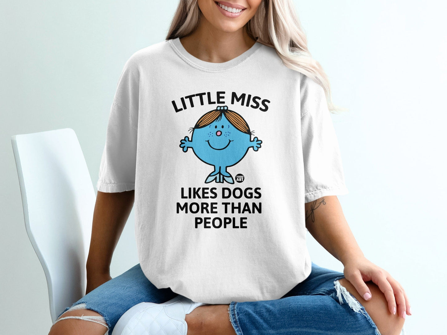 White t-shirt with "Little Miss Likes Dogs More Than People" text and cartoon.