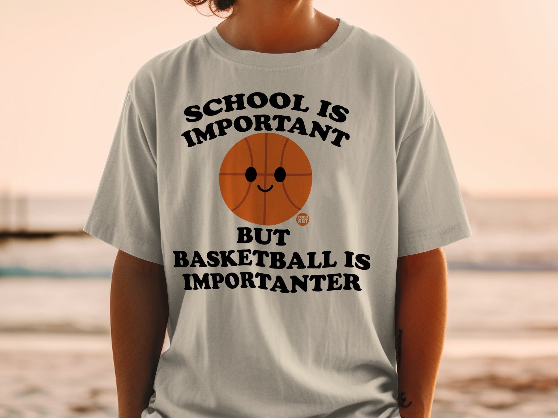 T-shirt with text "SCHOOL IS IMPORTANT BUT BASKETBALL IS IMPORTANTER" and a basketball graphic.