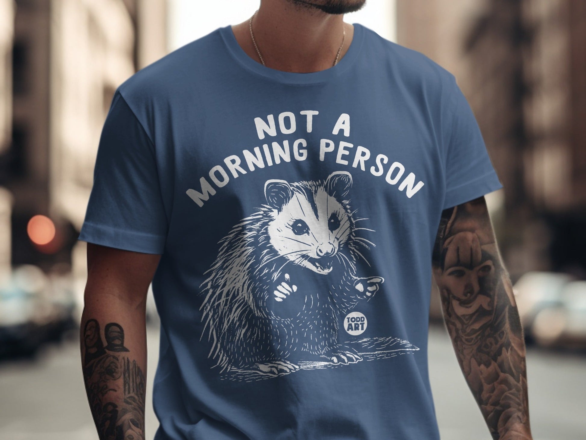 Blue t-shirt with "NOT A MORNING PERSON" text and opossum graphic.