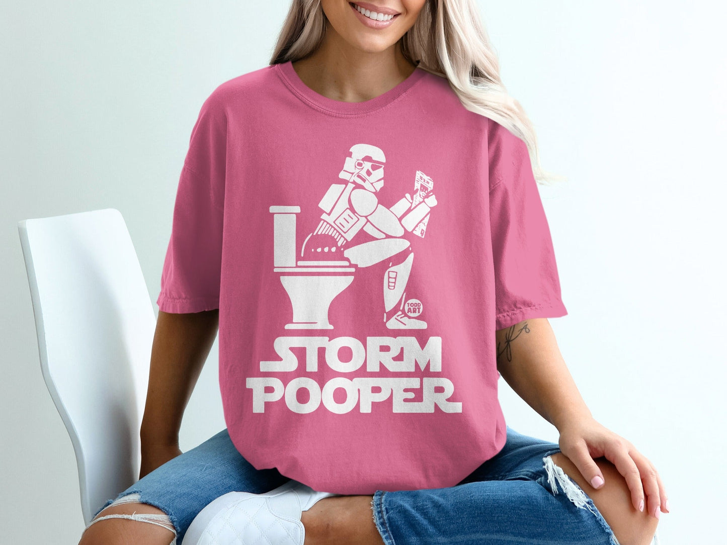 Stormtrooper sitting on toilet, reading phone, "STORM POOPER" text.