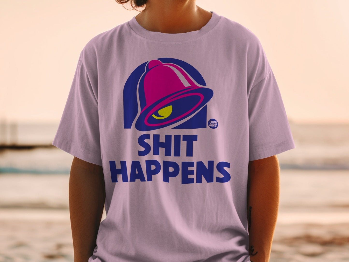 Light purple t-shirt with Taco Bell logo and "Shit Happens" text.