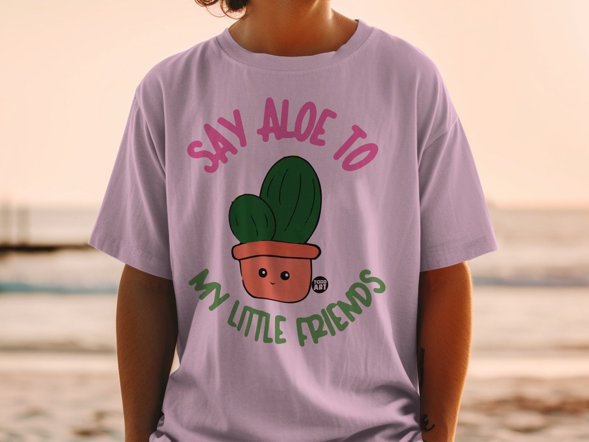 Light pink t-shirt with cartoon cactus saying "Say Aloe to My Little Friends".