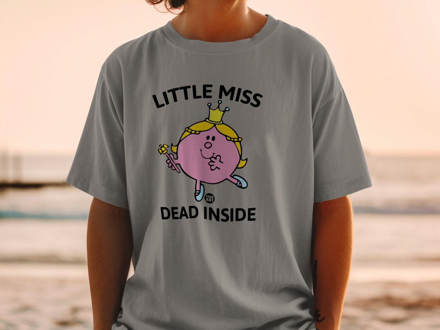 Little Miss Dead Inside graphic tee on a person, beach background