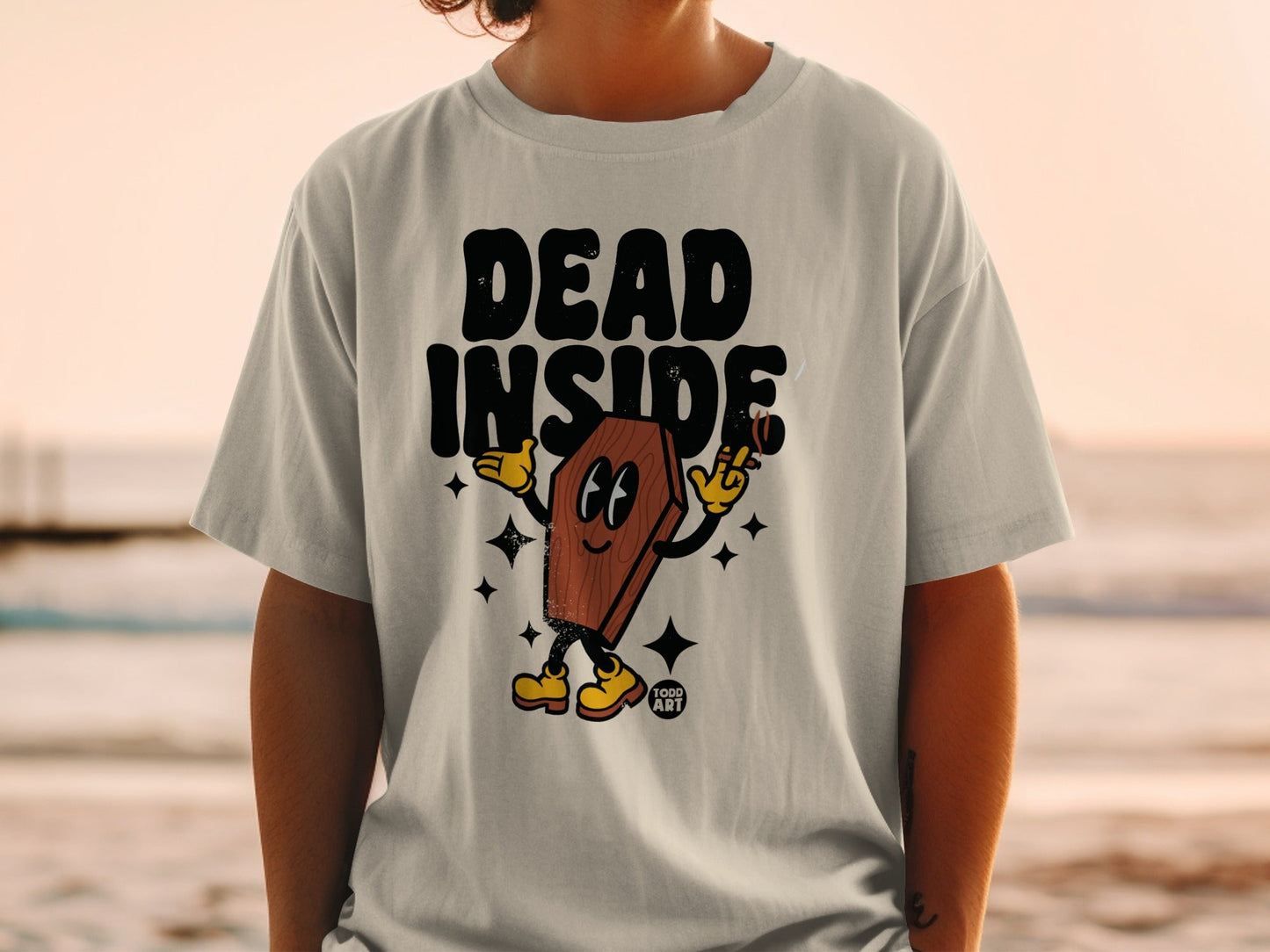 T-shirt with cartoon coffin character holding a cigarette and smiling.