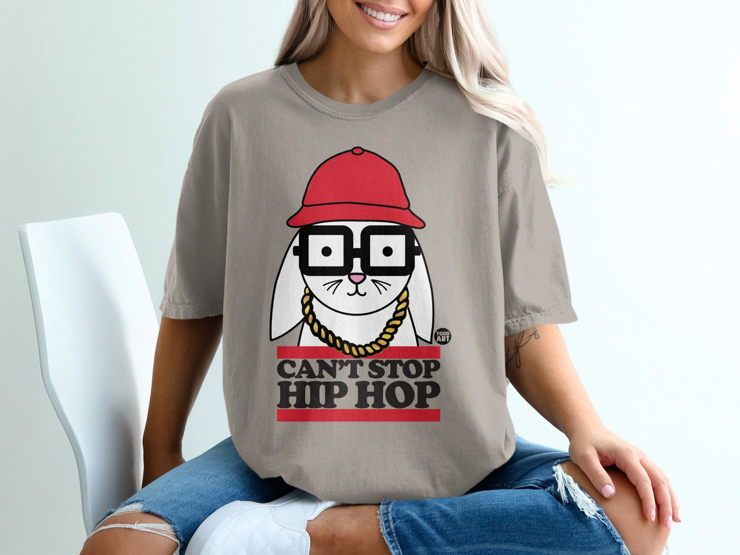 T-shirt with graphic of a bunny wearing glasses, red hat, and gold chain, reading "Can't Stop Hip Hop".