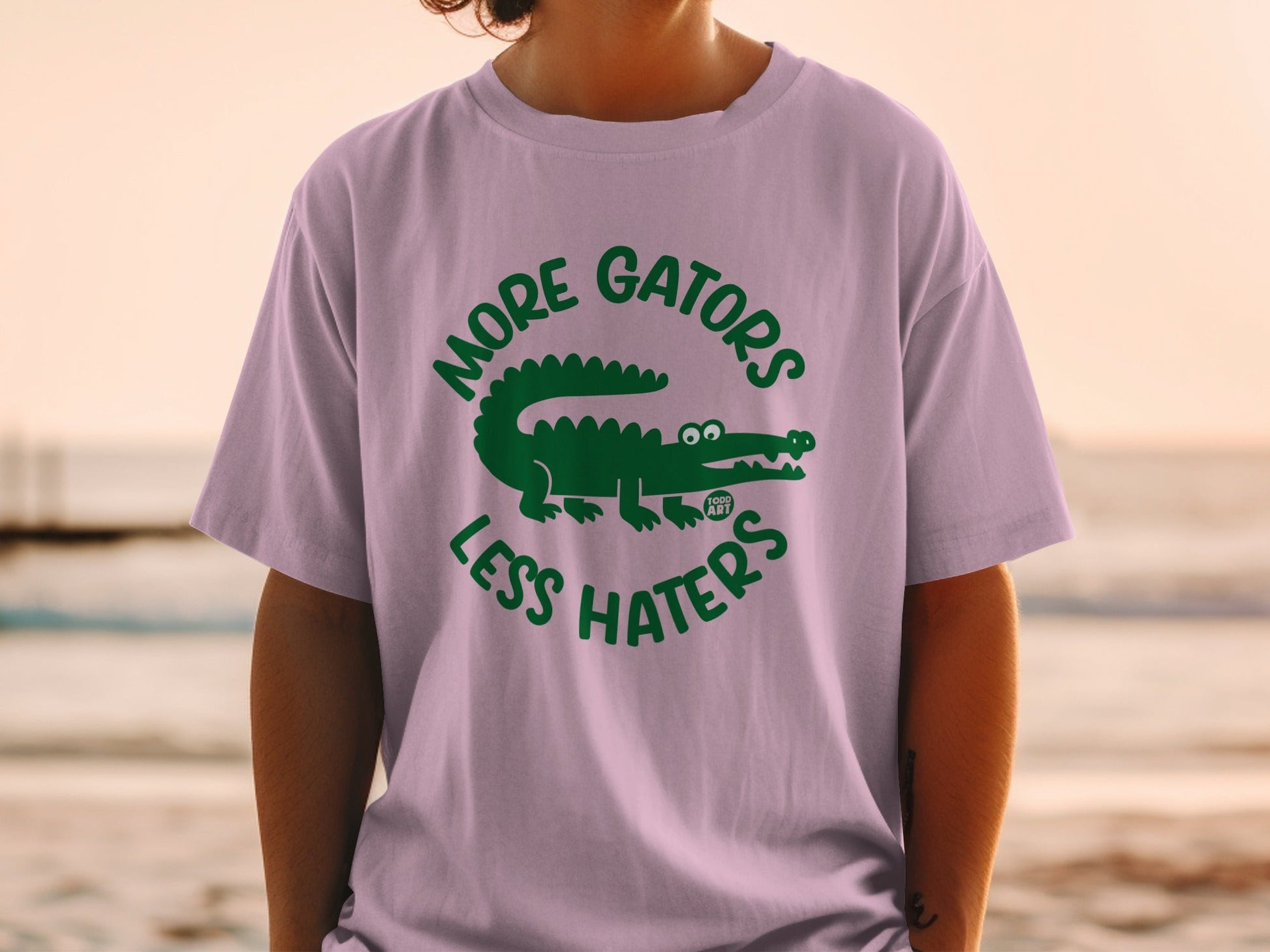 Purple t-shirt with green "MORE GATORS LESS HATERS" text and alligator graphic.