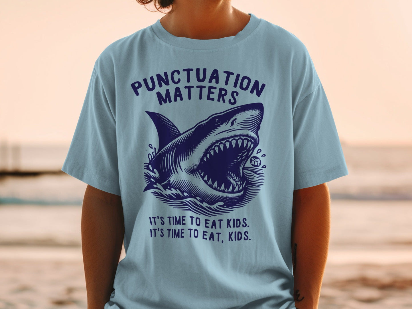 Blue t-shirt with a shark graphic and "Punctuation Matters" text.