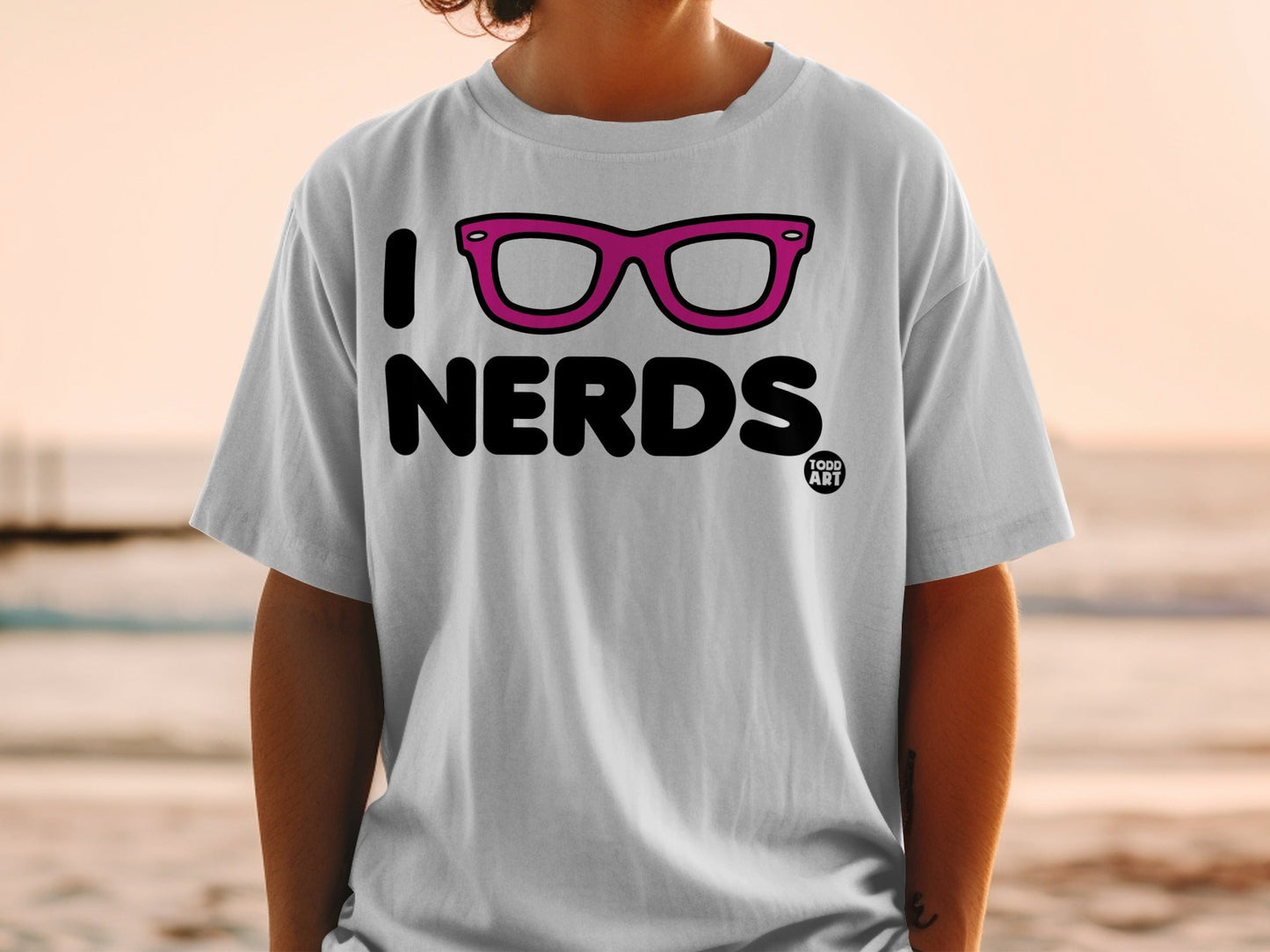 White t-shirt with "I [heart shape] NERDS" text and pink glasses.
