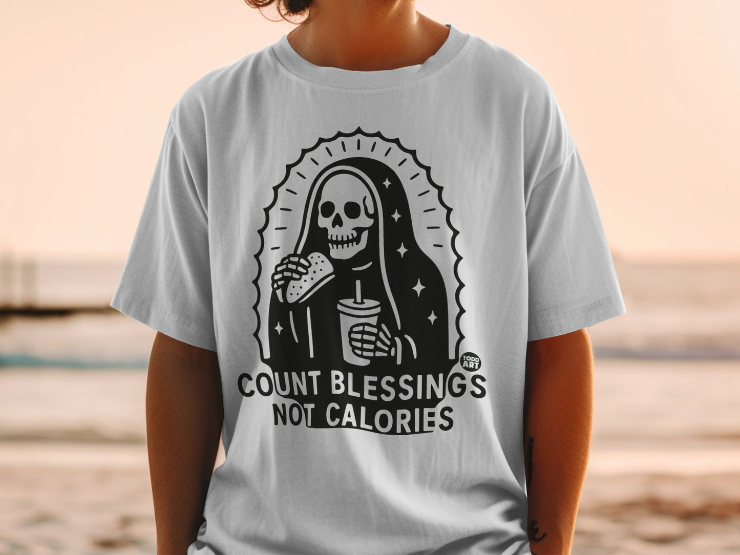T-shirt with Grim Reaper eating fast food, "COUNT BLESSINGS NOT CALORIES" text.