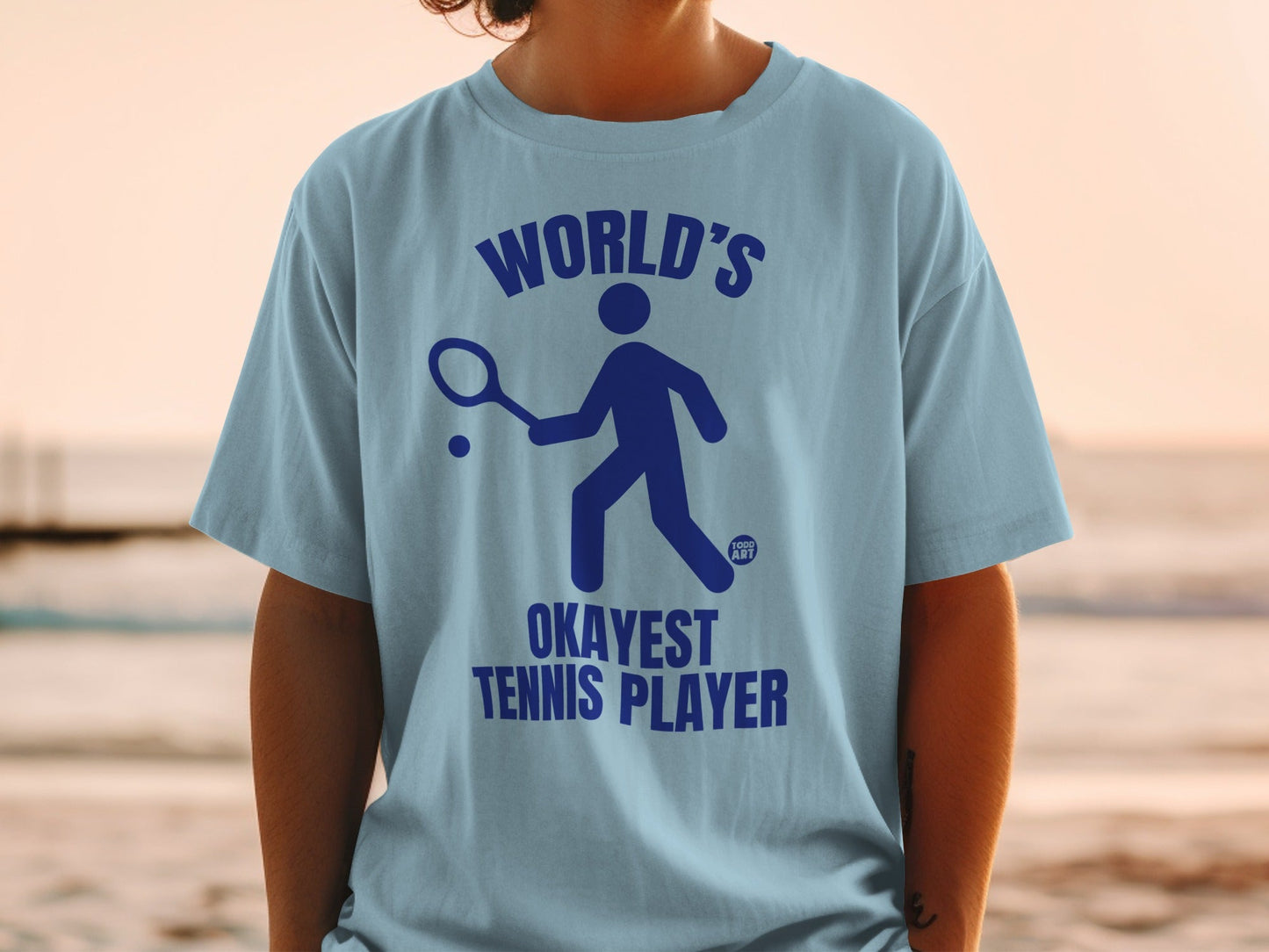 Light blue t-shirt with "World's Okayest Tennis Player" and a tennis player icon.
