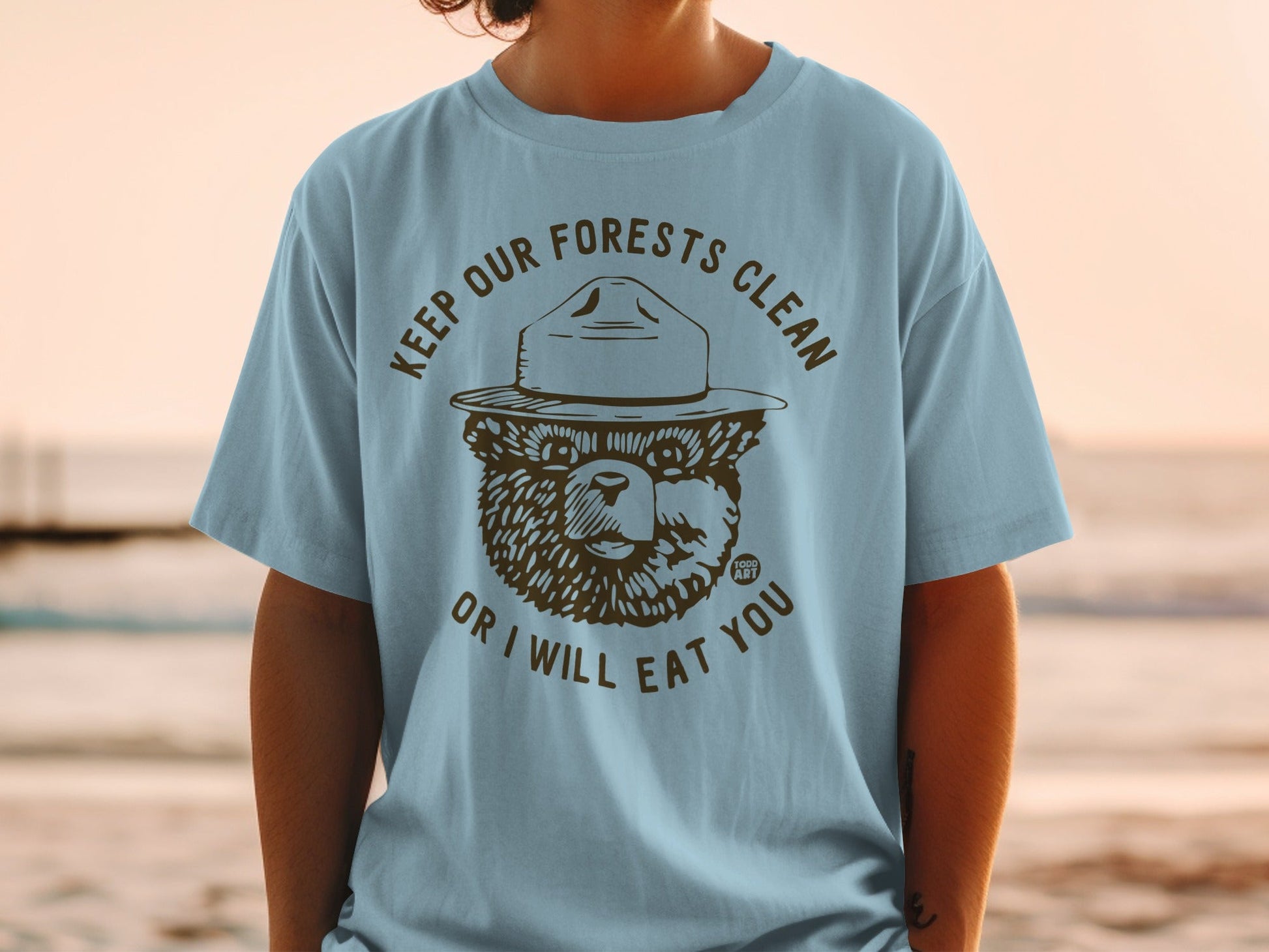Smokey Bear graphic on light blue t-shirt, "Keep Our Forests Clean or I Will Eat You".