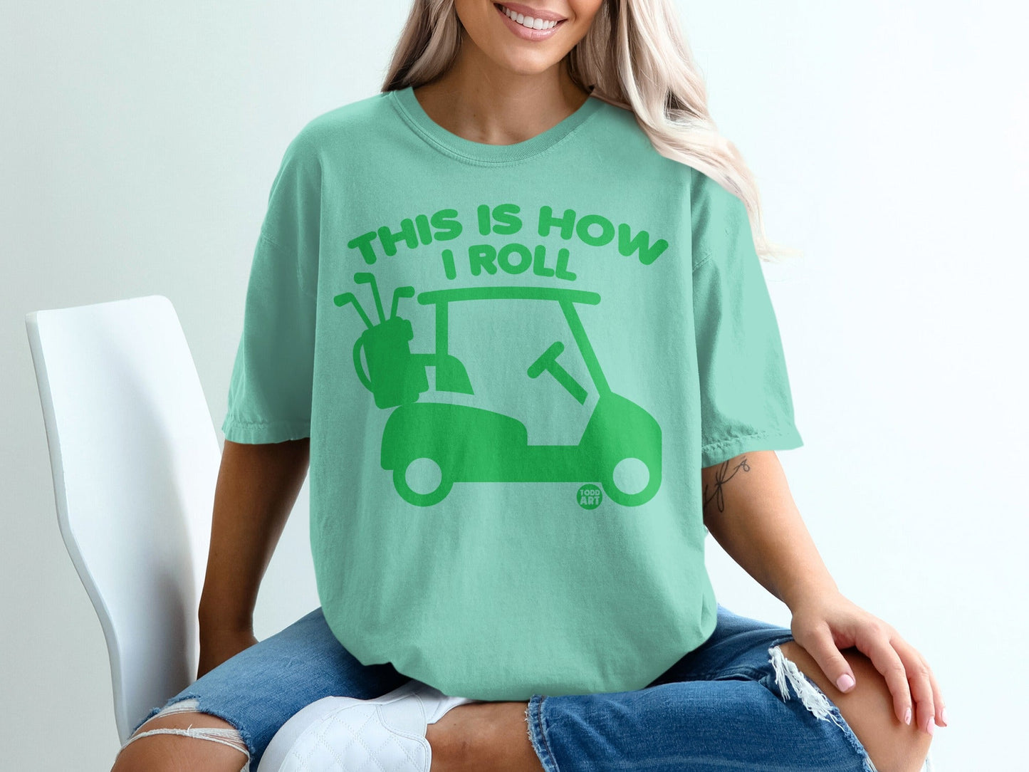 Mint t-shirt with green "This is how I roll" text and golf cart graphic.