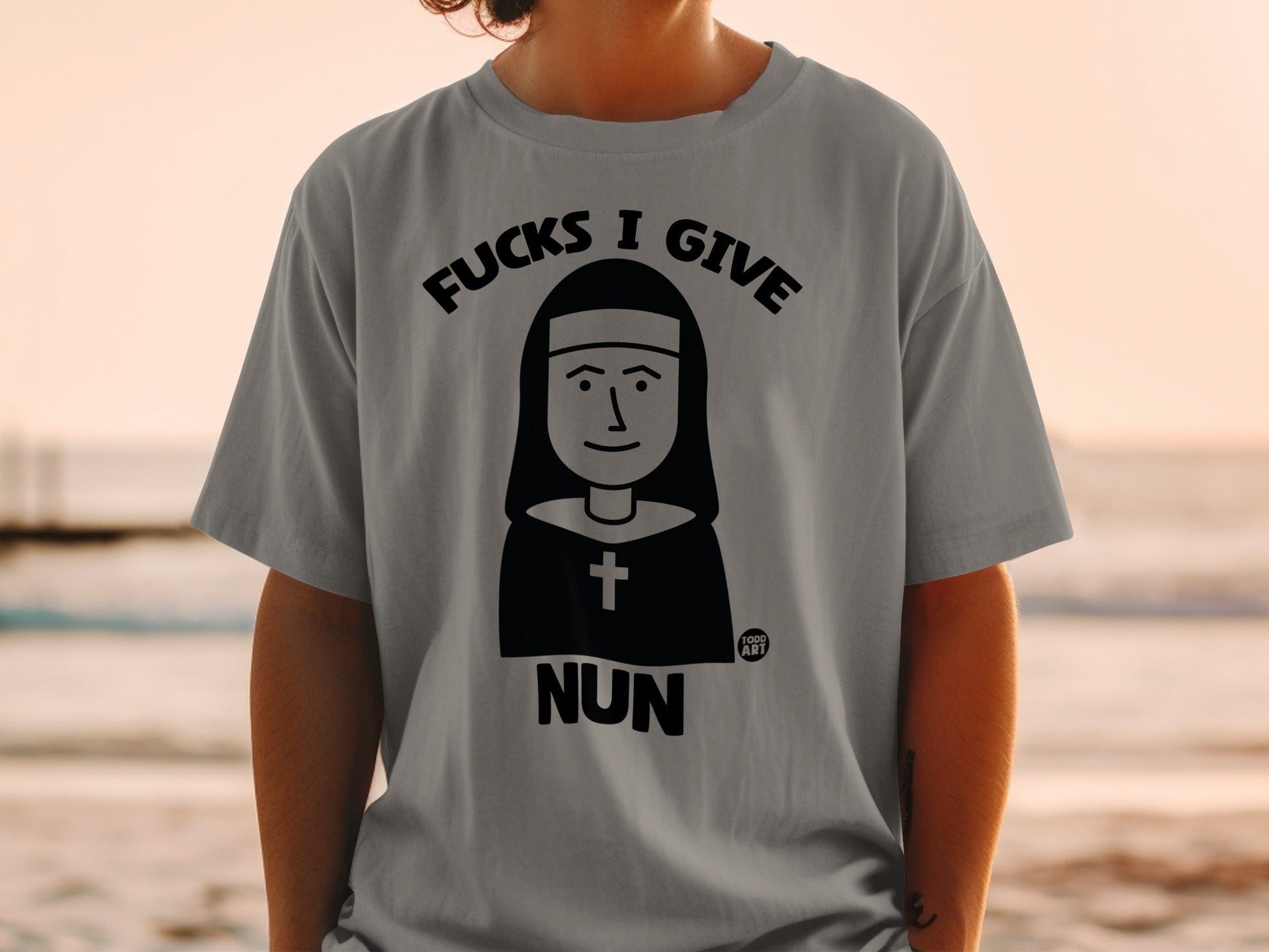 Gray t-shirt with "Fucks I Give Nun" graphic and nun illustration.