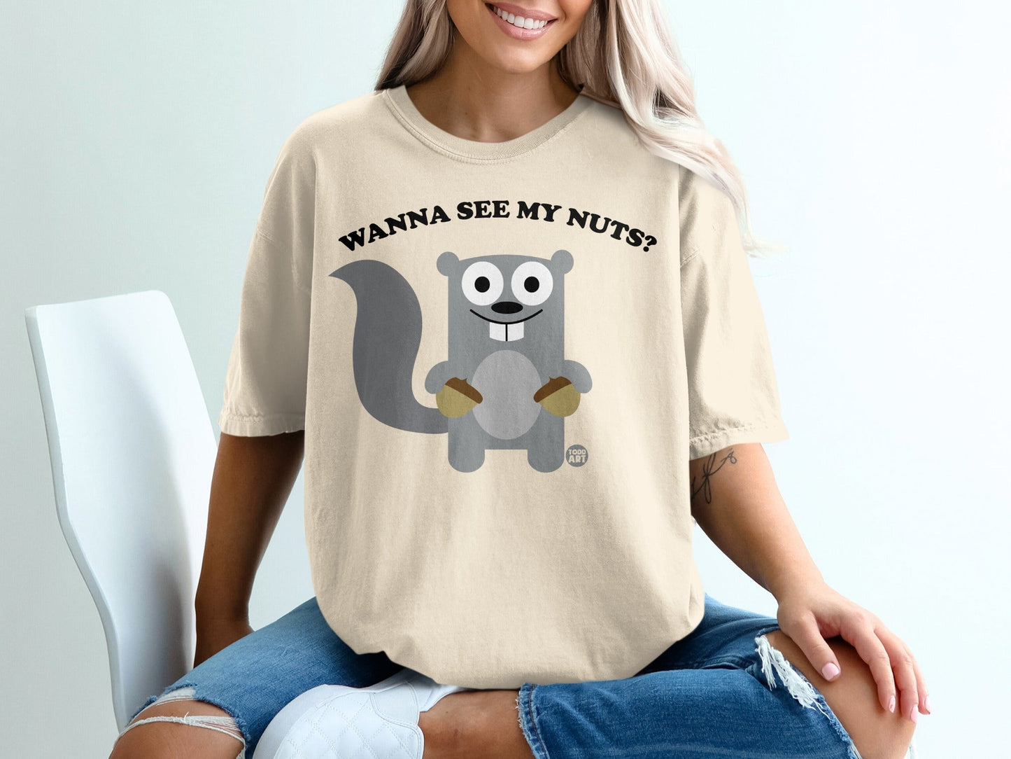 Cartoon squirrel holding two acorns, text "Wanna see my nuts?".