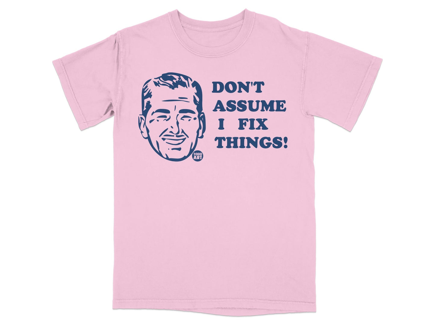 Pink t-shirt with dark blue graphic of a man's face and text "DON'T ASSUME I FIX THINGS!".