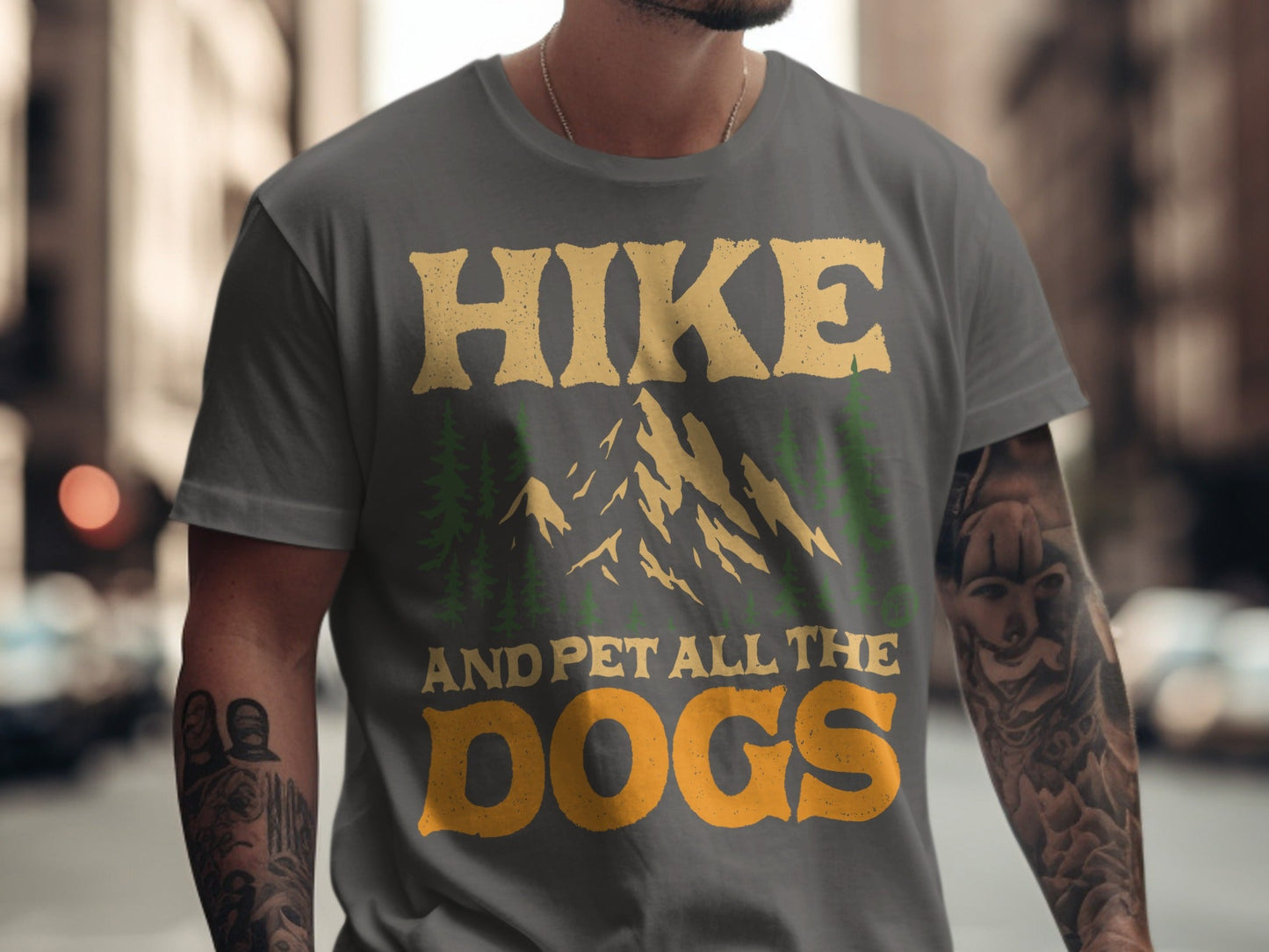 Grey t-shirt with "Hike and pet all the dogs" text and mountain graphic.