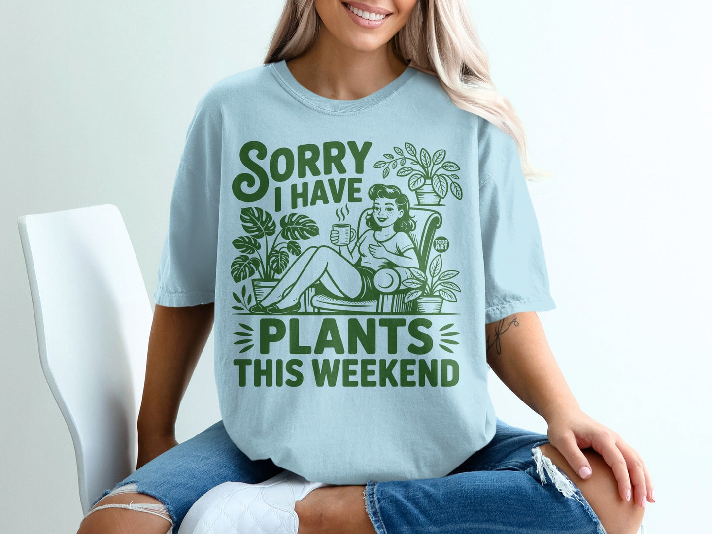 Light blue t-shirt with green text "SORRY I HAVE PLANTS THIS WEEKEND" and plant illustrations.