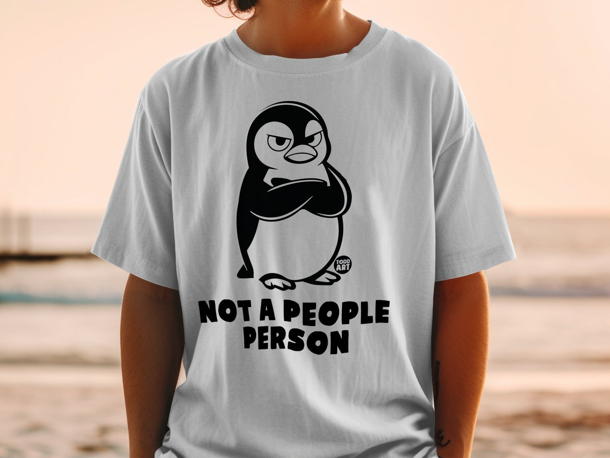 White t-shirt with grumpy penguin and "NOT A PEOPLE PERSON" text.