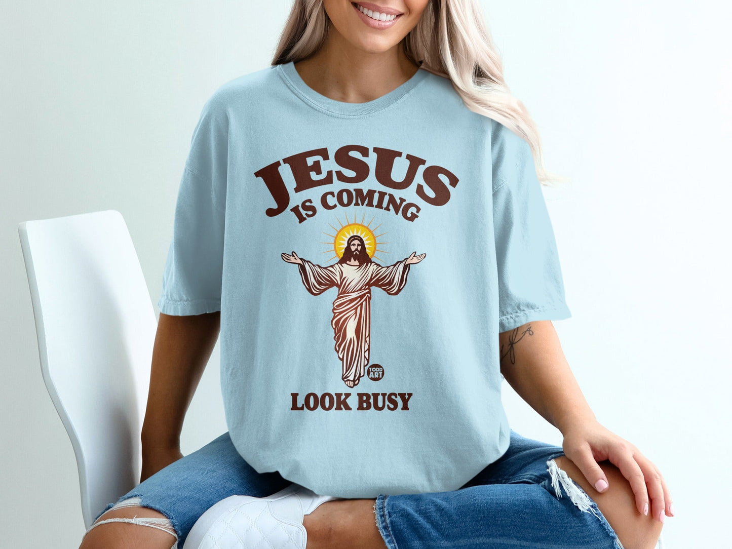 Jesus is coming, look busy graphic on a light blue t-shirt.