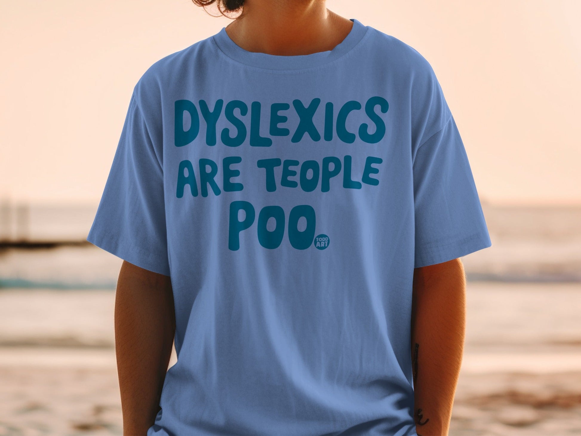 Blue t-shirt with "DYSLEXICS ARE TEOPLE POO" printed in white text.