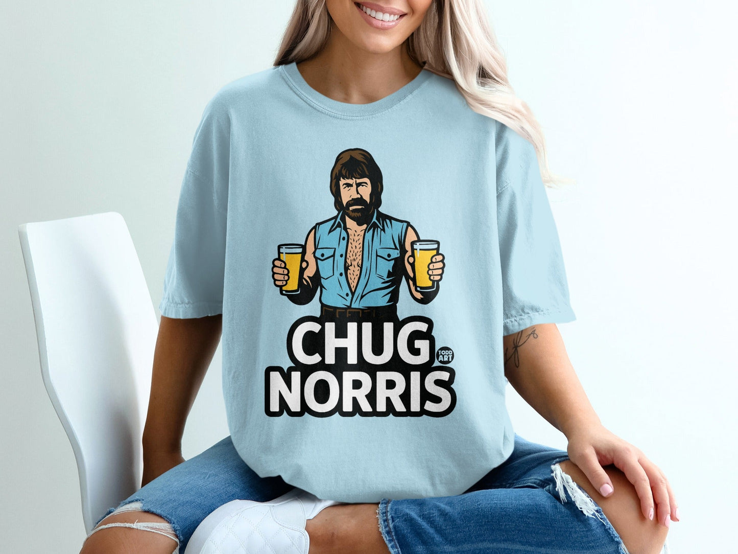 Chuck Norris illustration with two beers on a light blue t-shirt.