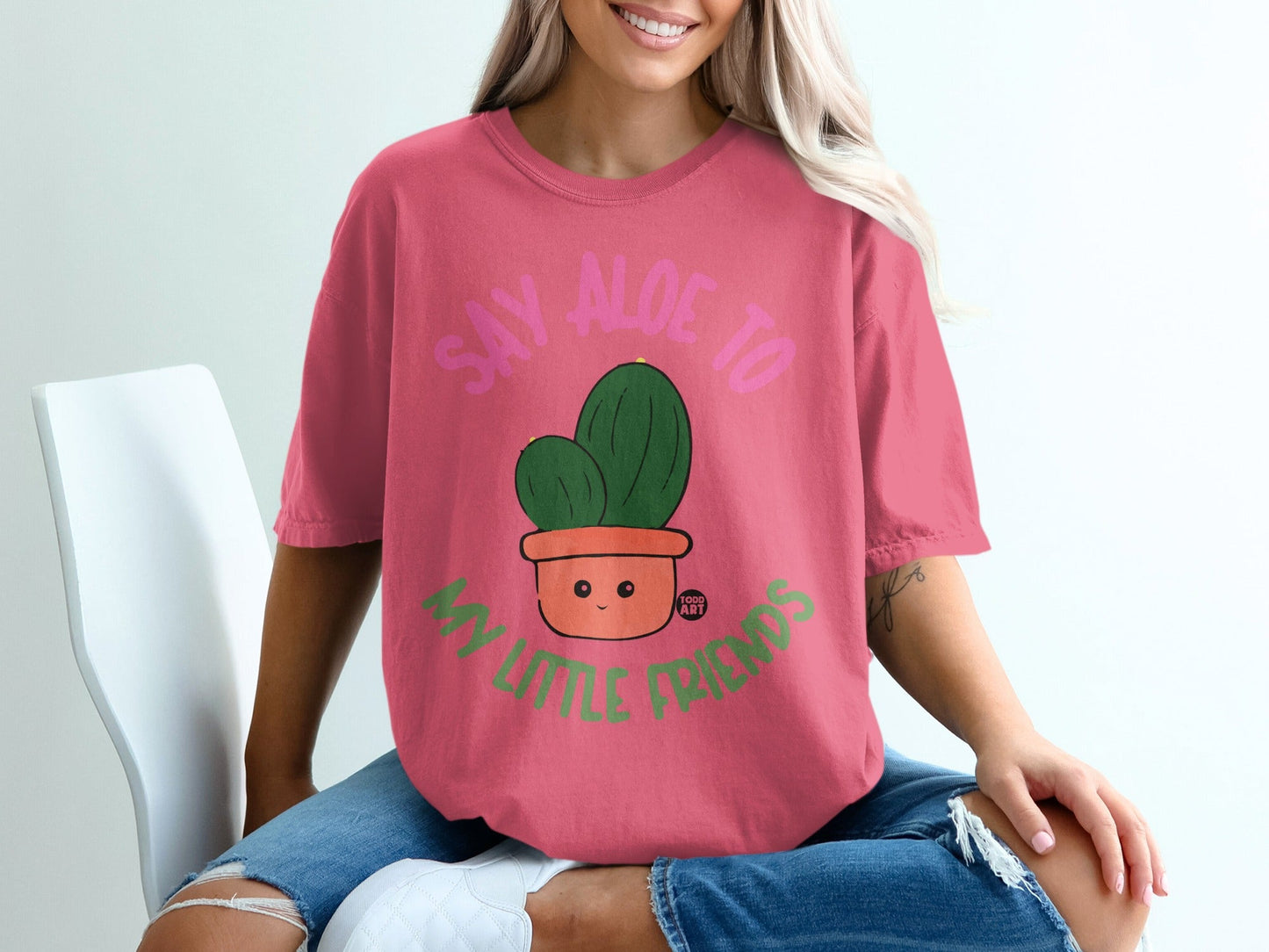 Pink t-shirt with "Say Aloe to My Little Friends" text and cartoon cactus.