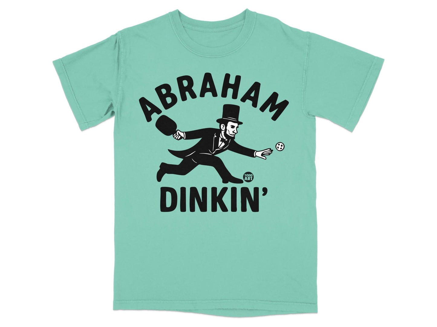 Abraham Lincoln playing pickleball on a light teal t-shirt.