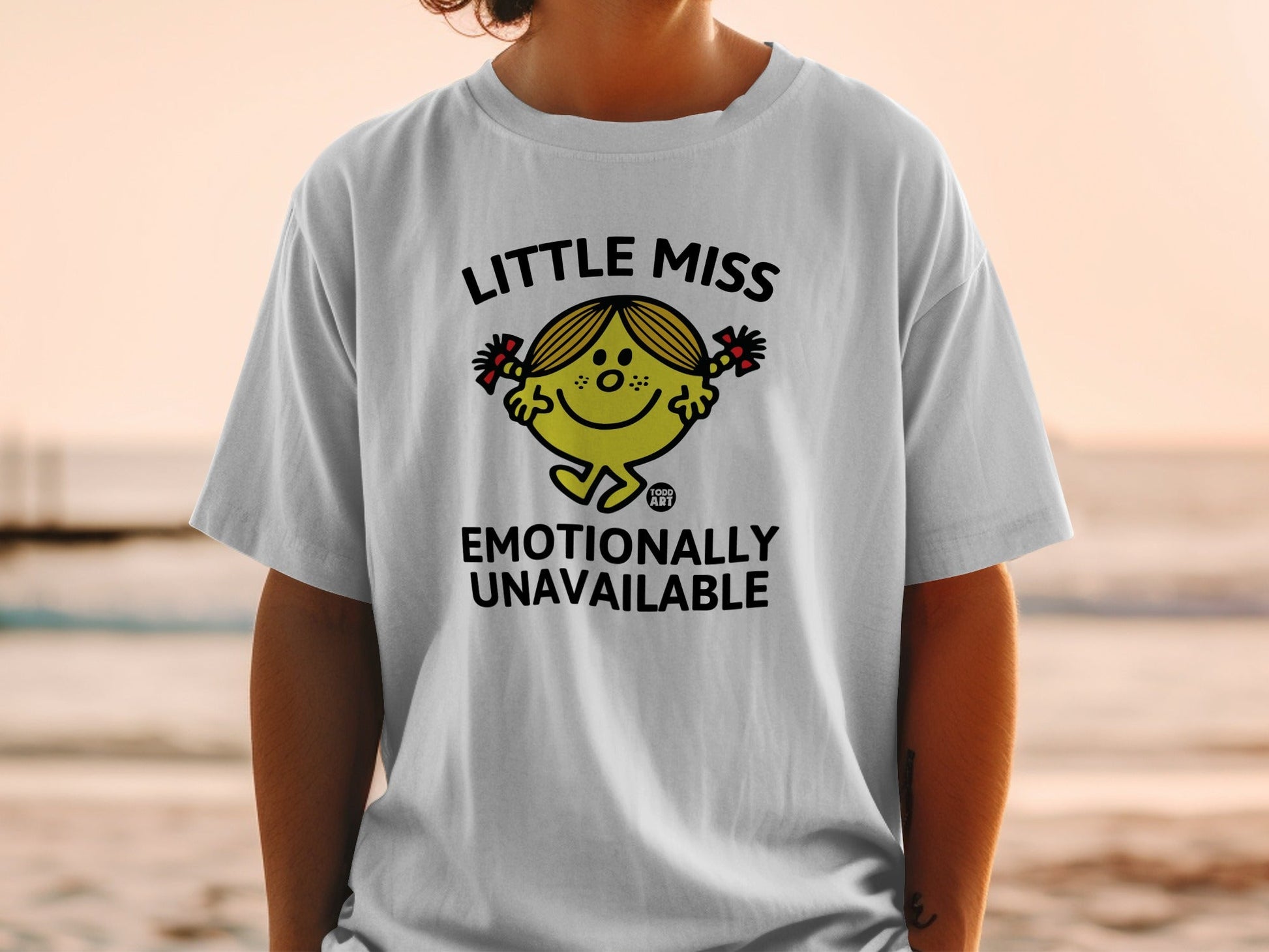 White t-shirt featuring Little Miss character saying "Emotionally Unavailable."