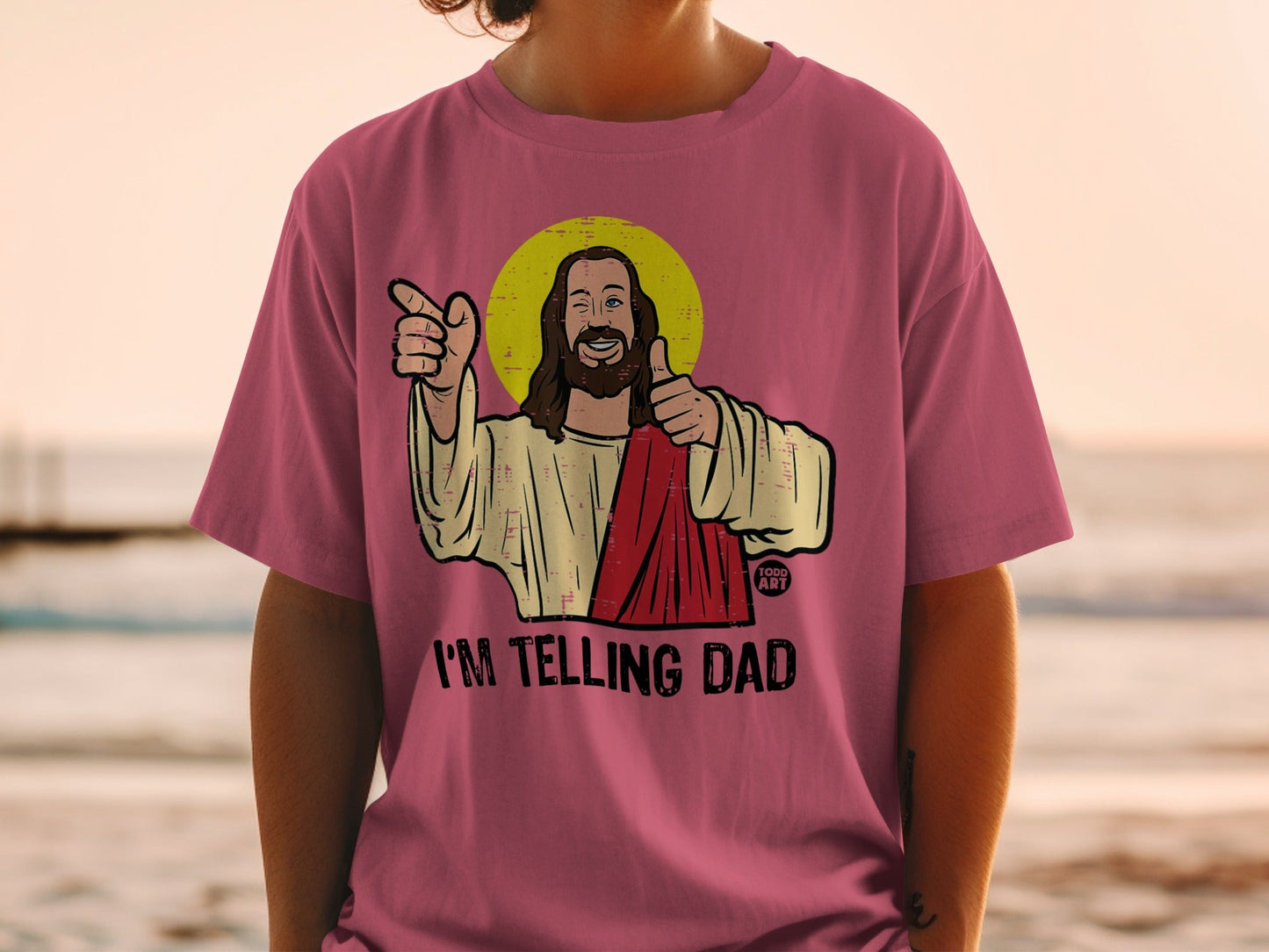 T-shirt with Jesus giving a thumbs up and pointing, text "I'M TELLING DAD".