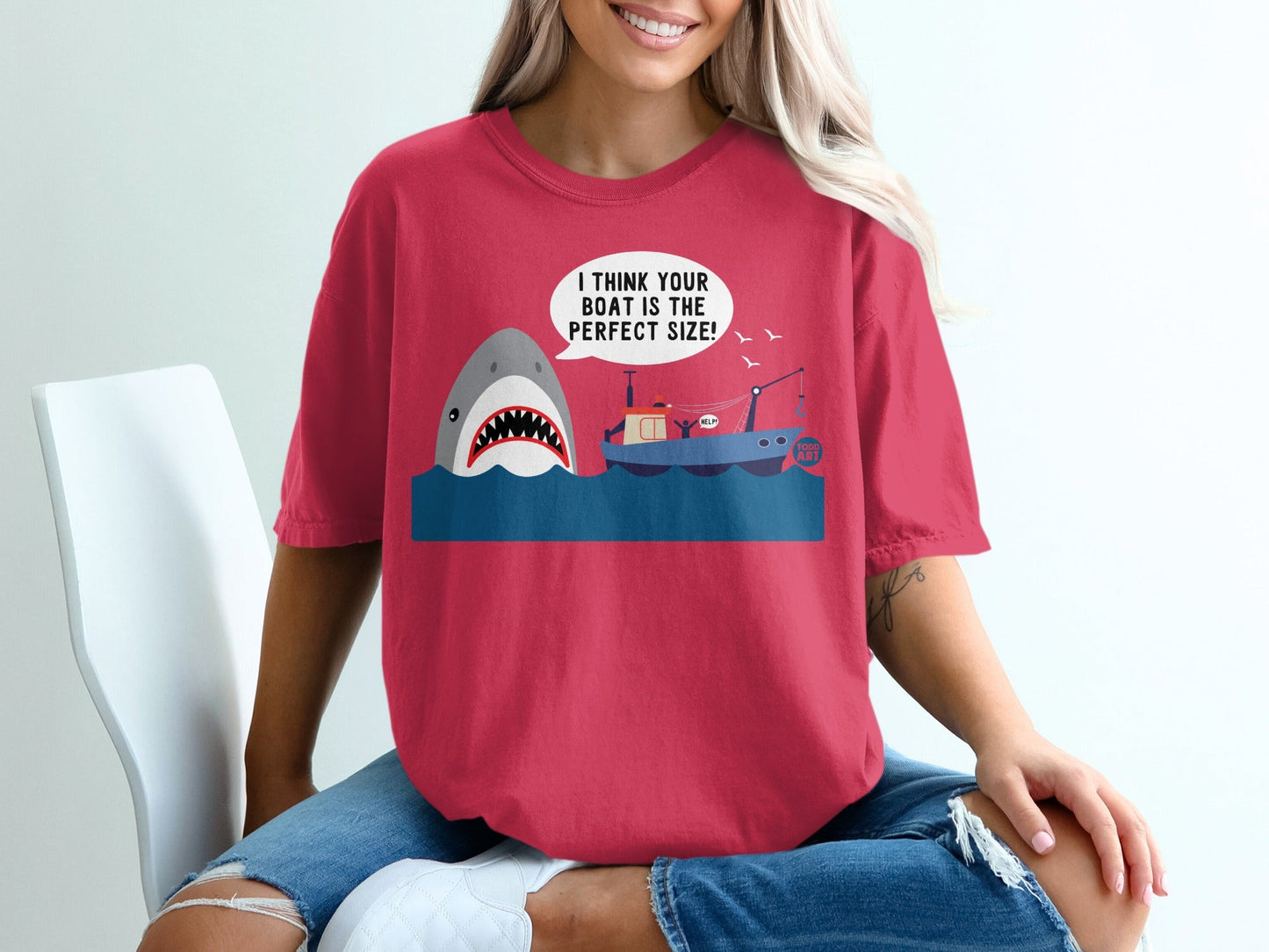 T-shirt with shark, boat, and speech bubble that reads "I THINK YOUR BOAT IS THE PERFECT SIZE!".