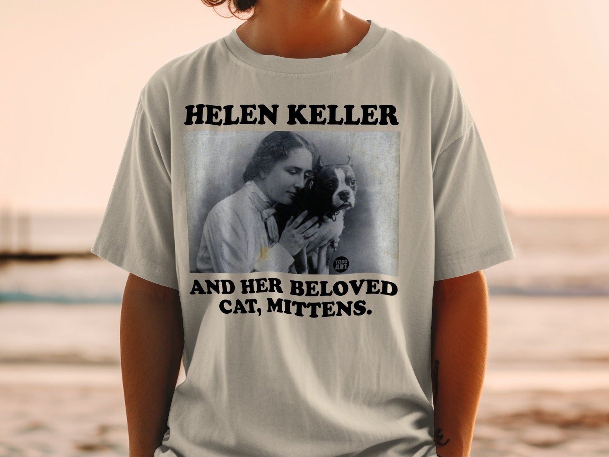 Helen Keller and her cat Mittens in a t-shirt graphic.