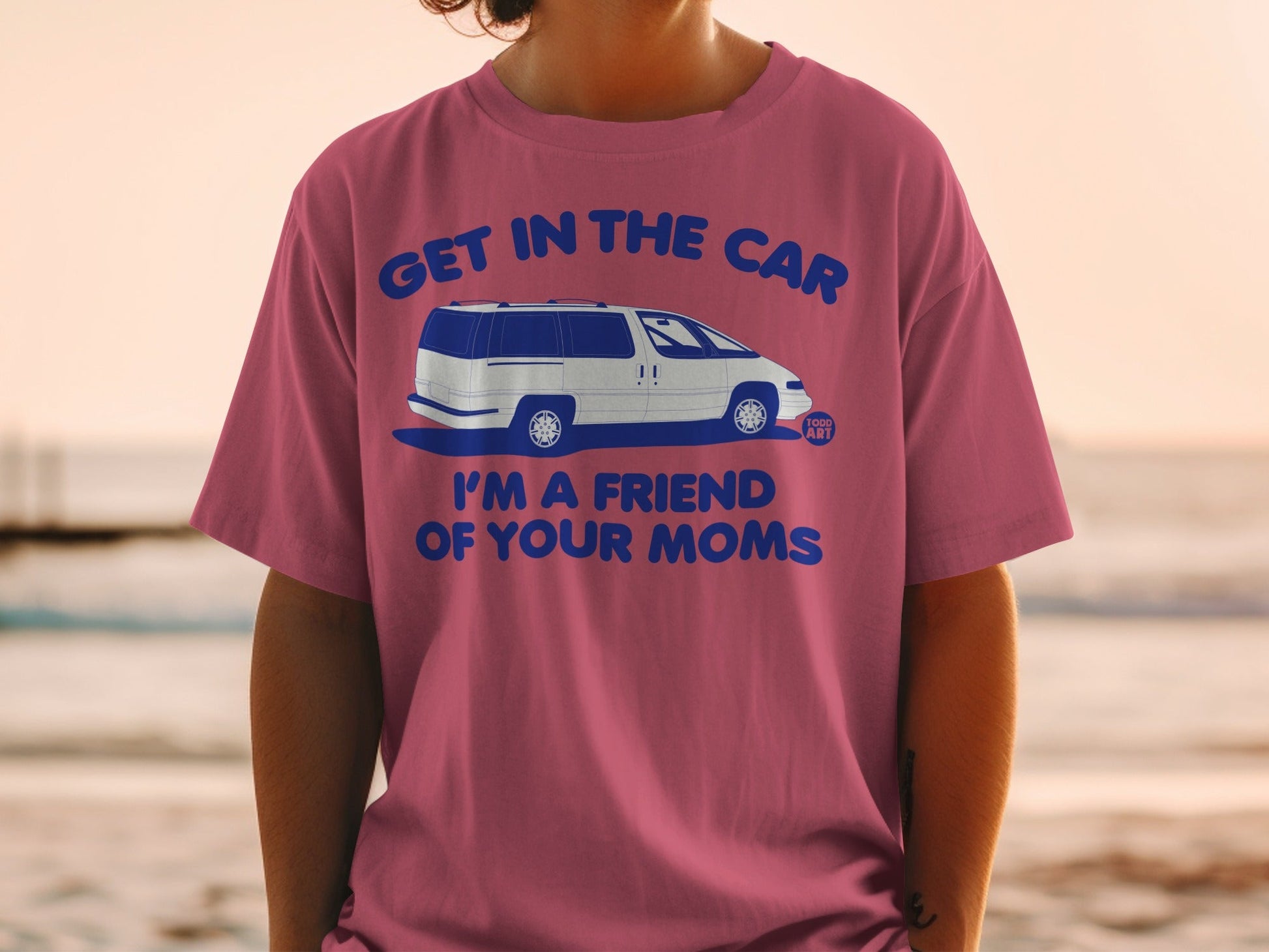 Pink t-shirt with blue text "GET IN THE CAR I'M A FRIEND OF YOUR MOMS" and a minivan graphic.