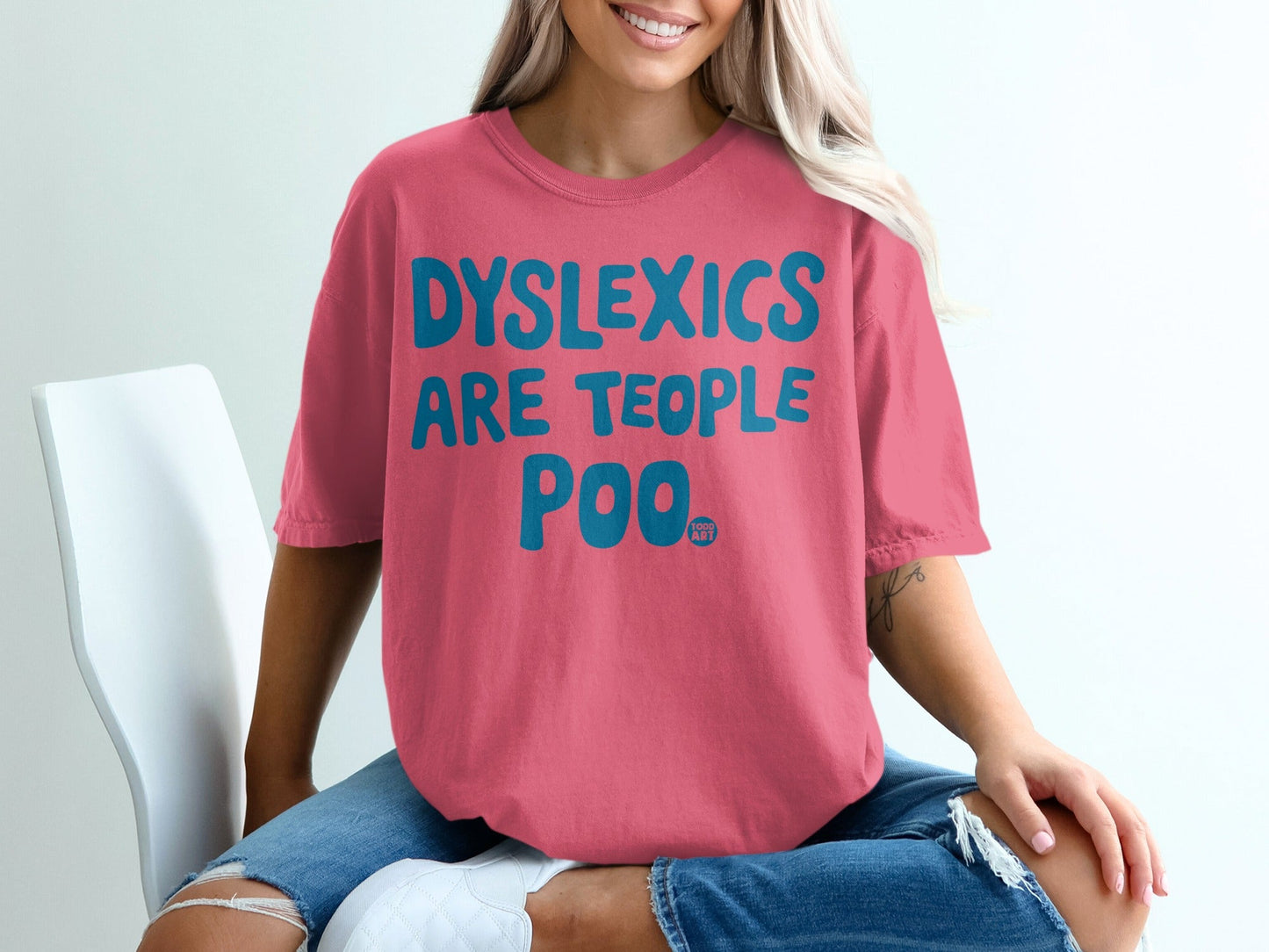 Pink t-shirt with "DYSLEXICS ARE TEOPLE POO" in teal text.
