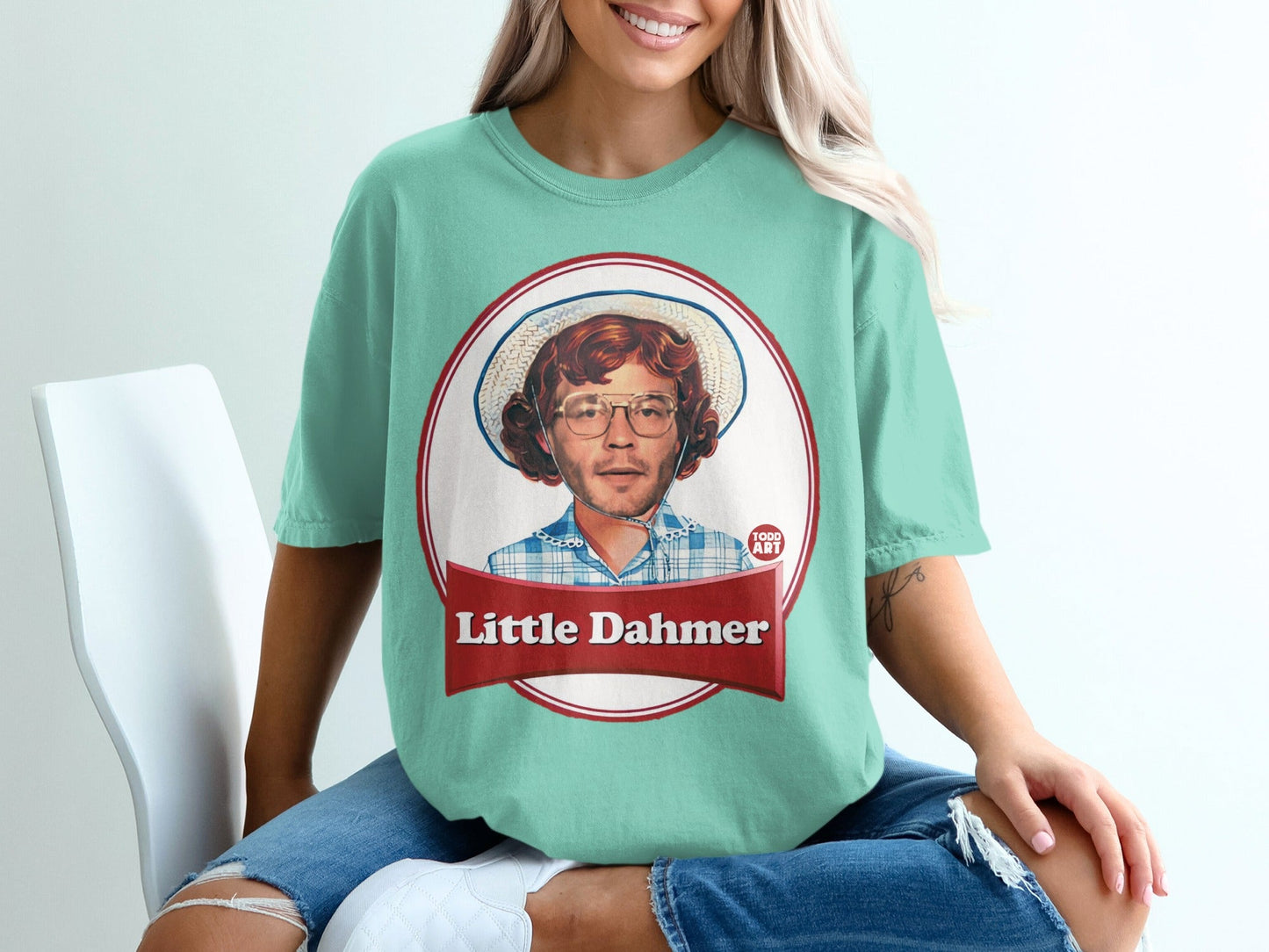 Teal t-shirt with graphic of a man wearing glasses and a straw hat.