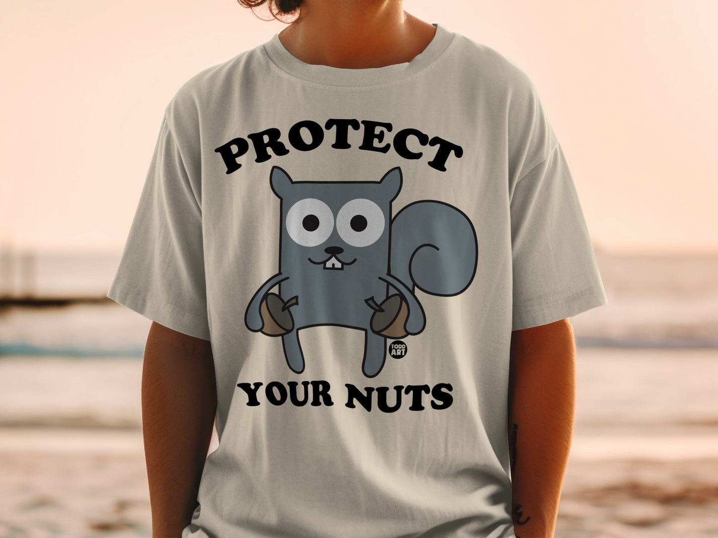 Cartoon squirrel with acorns wearing a t-shirt that says "PROTECT YOUR NUTS".