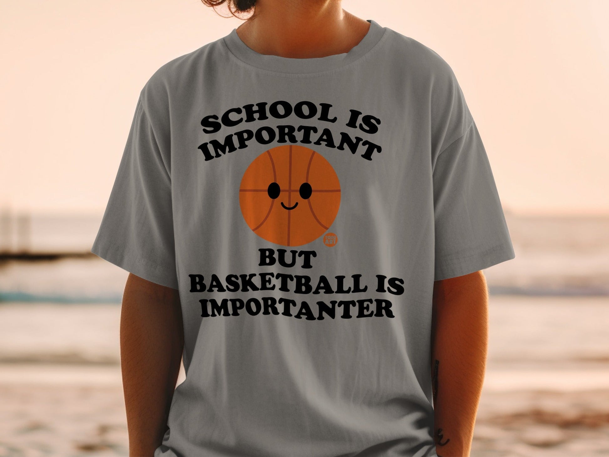 Gray t-shirt with text "School is important but basketball is importanter" and a cartoon basketball.