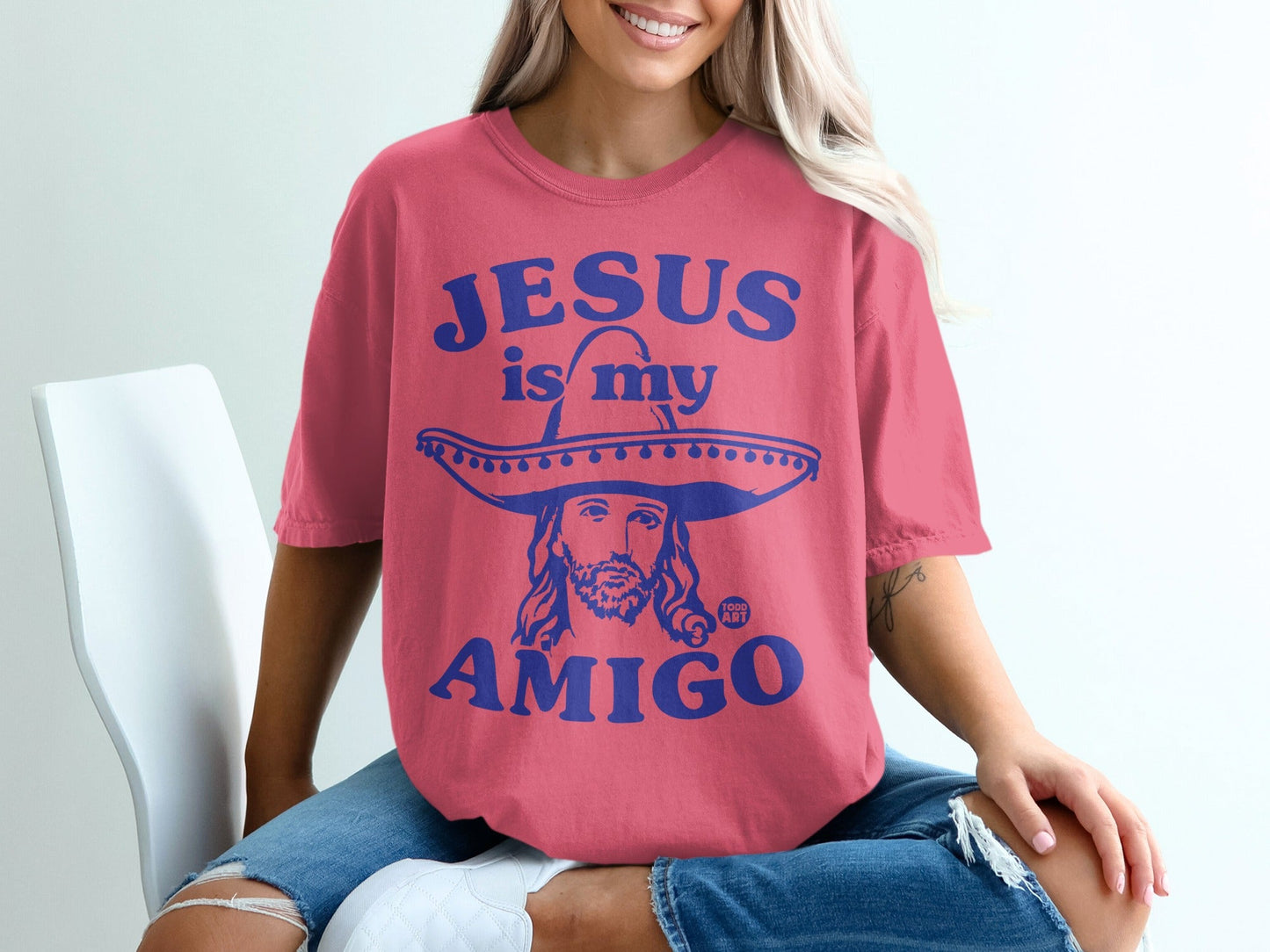 Pink t-shirt with "Jesus is my amigo" text and an illustration of Jesus in a sombrero.