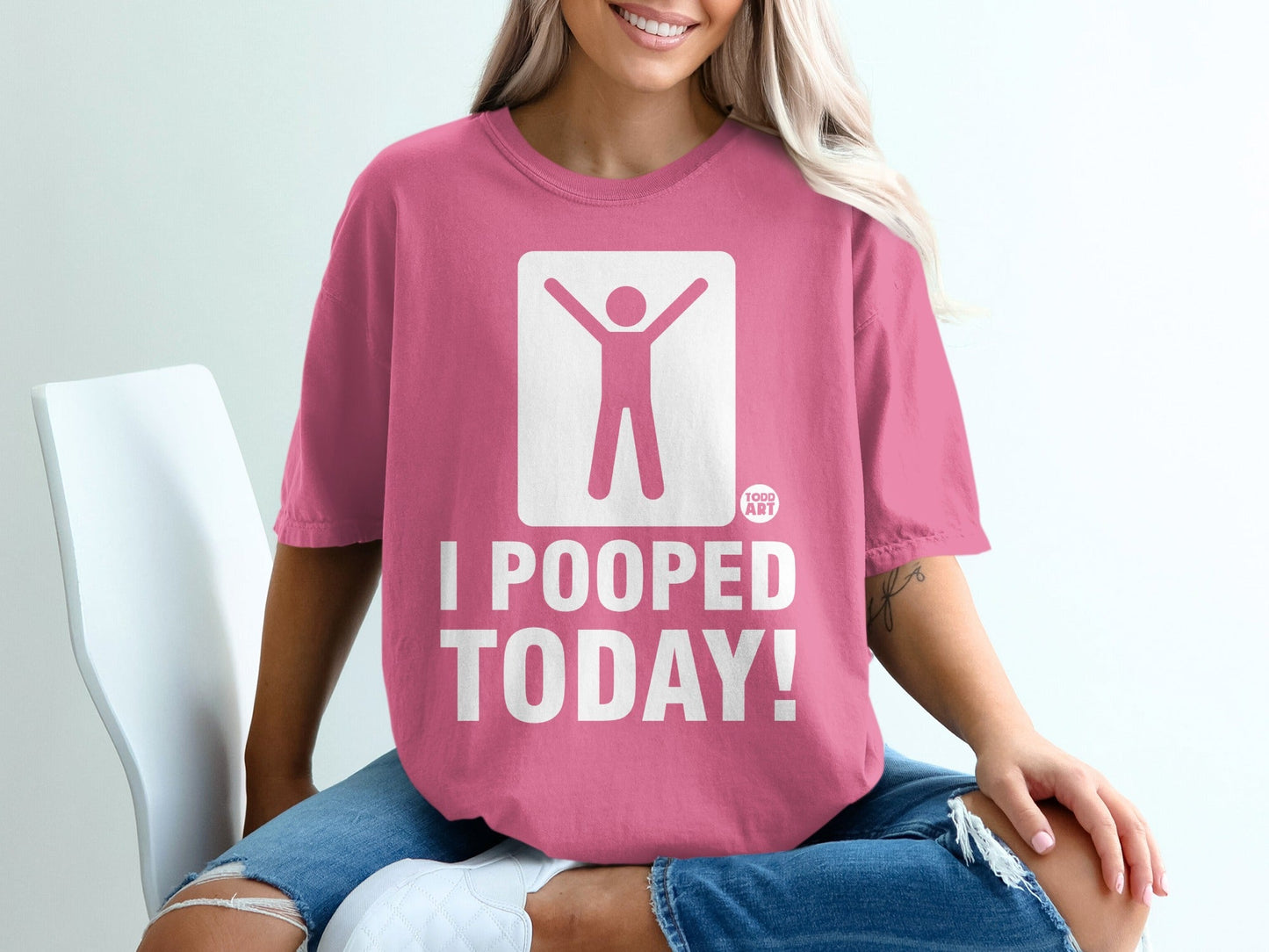 Pink t-shirt with graphic of person with arms raised and text "I POOPED TODAY!".