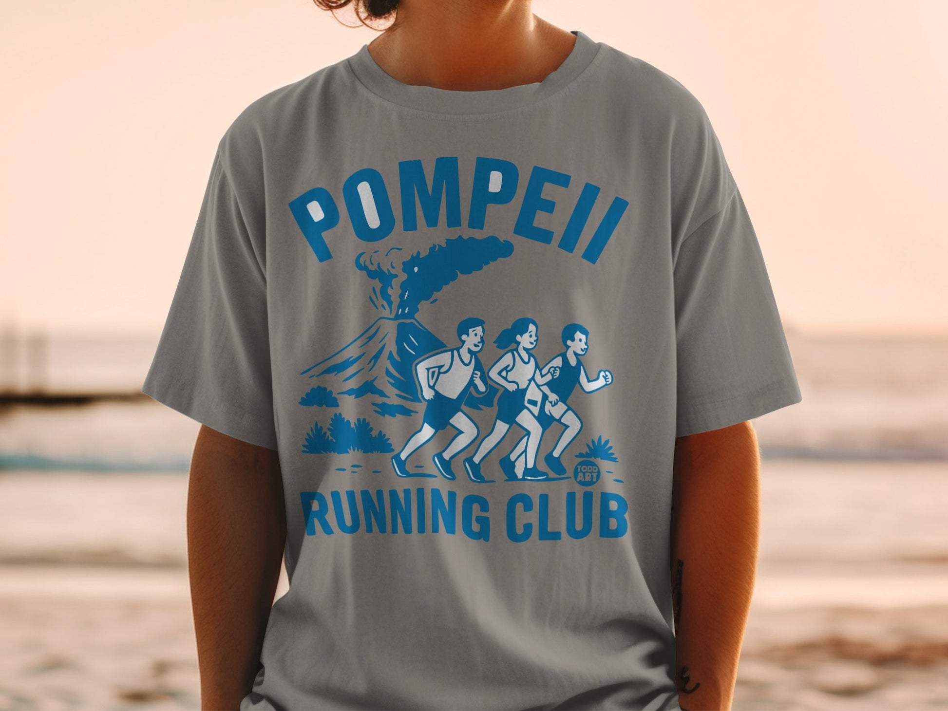 Grey t-shirt with Pompeii Running Club logo featuring a volcano and runners.