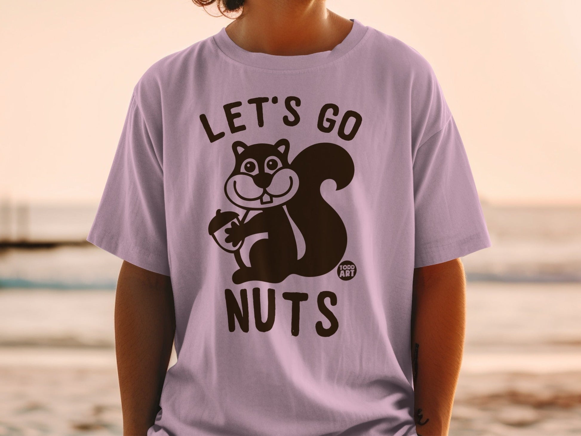 T-shirt with cartoon squirrel holding acorn, text "LET'S GO NUTS".