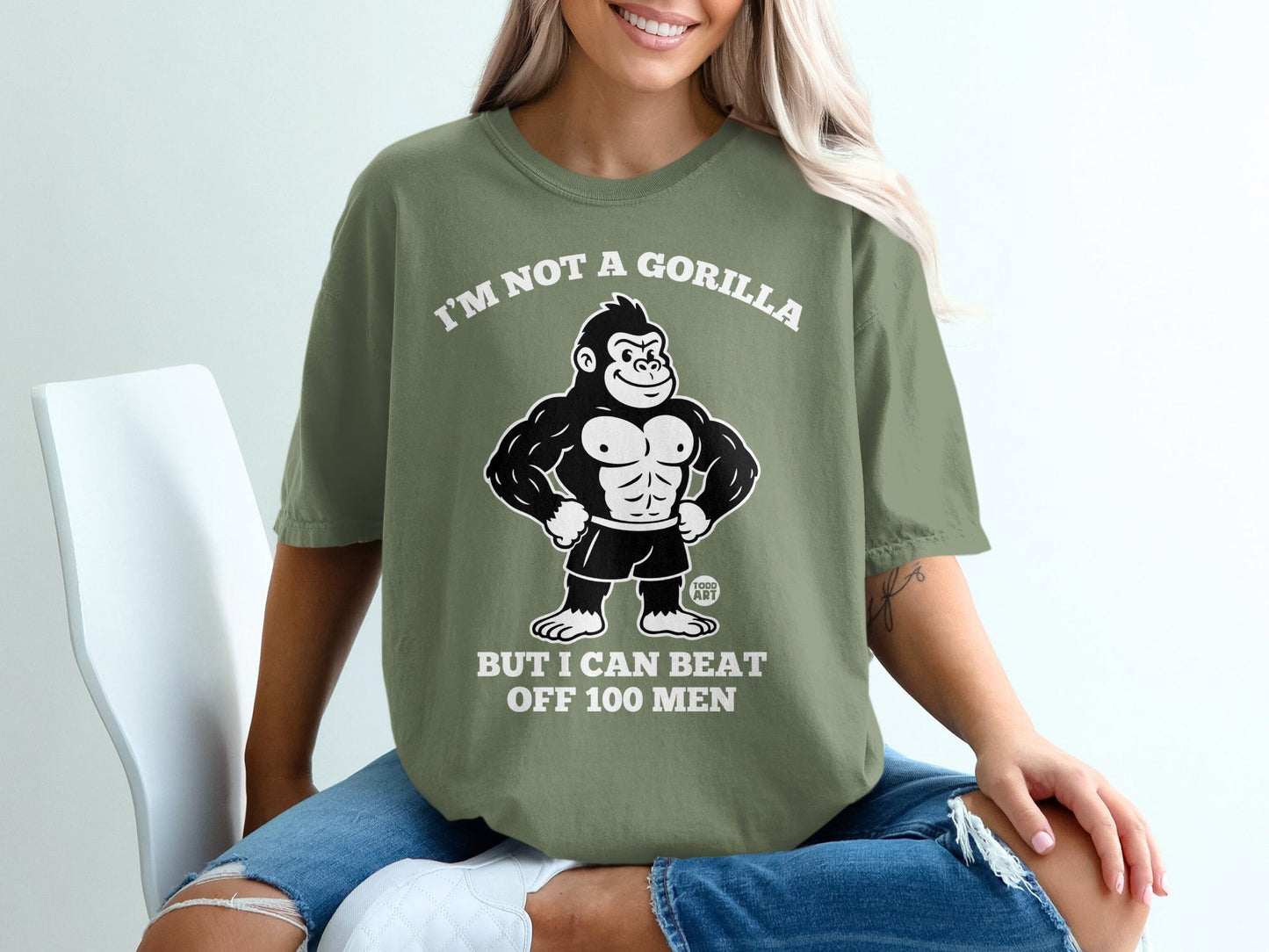 Olive green t-shirt with a cartoon gorilla and text: "I'm not a gorilla but I can beat off 100 men."