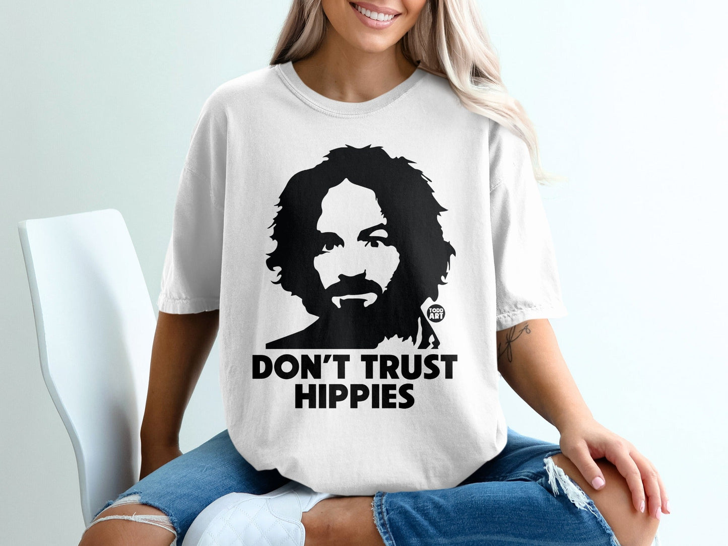 White t-shirt with a black graphic of Charles Manson and "DON'T TRUST HIPPIES" text.