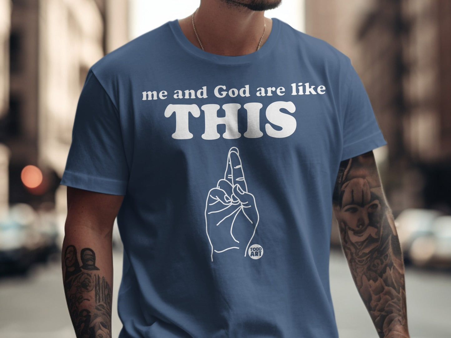 Blue t-shirt with white text "me and God are like THIS" and a hand gesture.