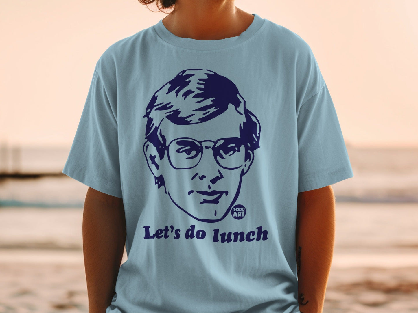 Light blue t-shirt with a graphic of a person's face and "Let's do lunch".