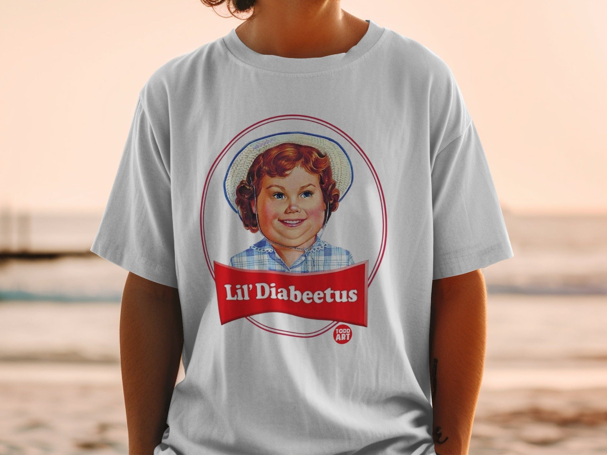 T-shirt with child's face in a red circle logo, text "Lil' Diabeetus".